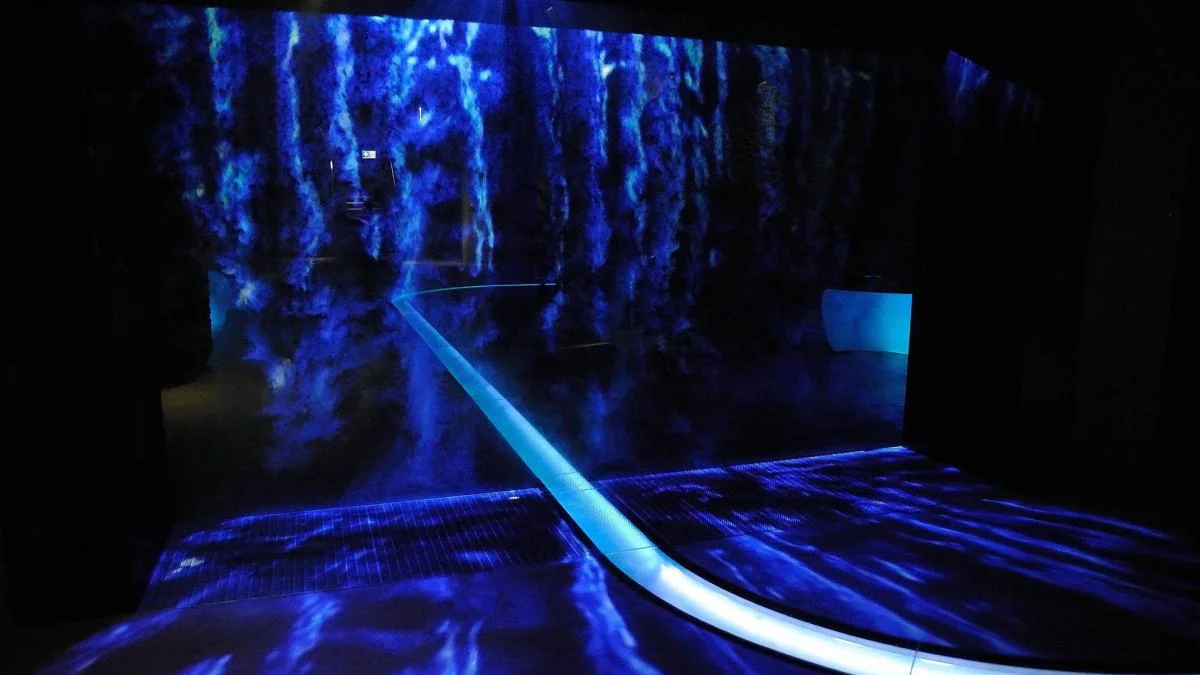 Deep blue projected water surface filling a darkened room