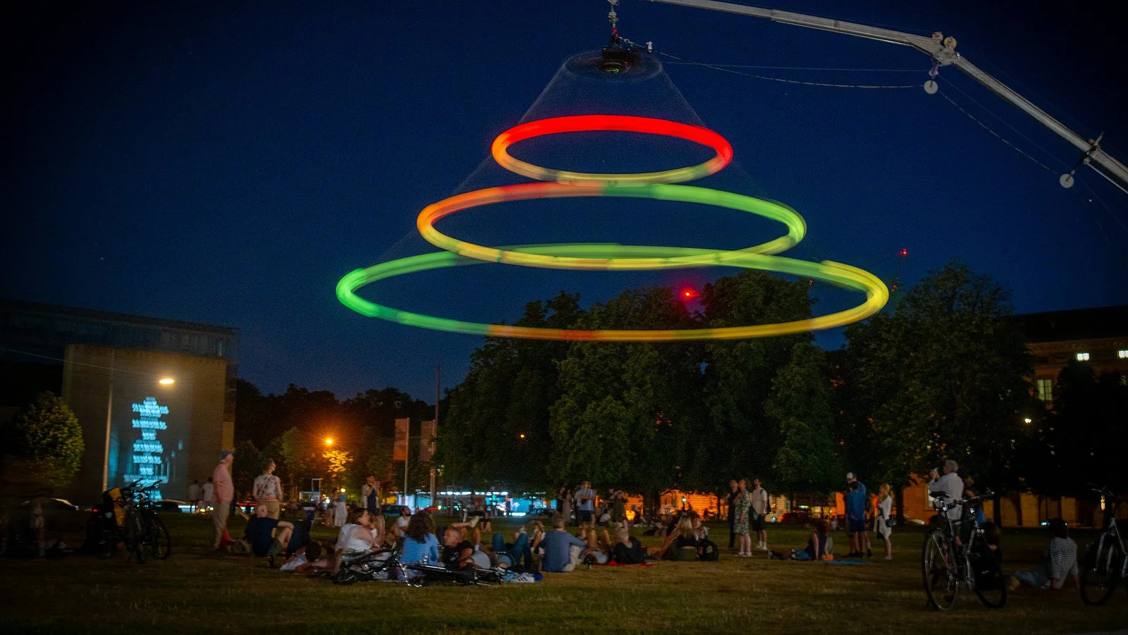 The illuminated ring installation suspended above the festival crowd at night